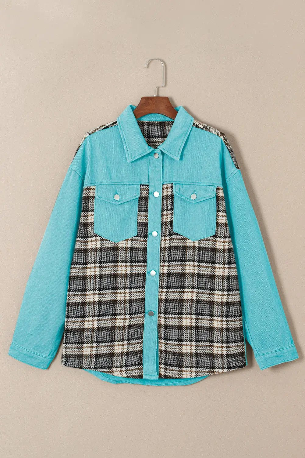 a blue and black plaid shirt hanging on a hanger