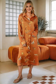 a woman standing in a room wearing an orange shirt dress