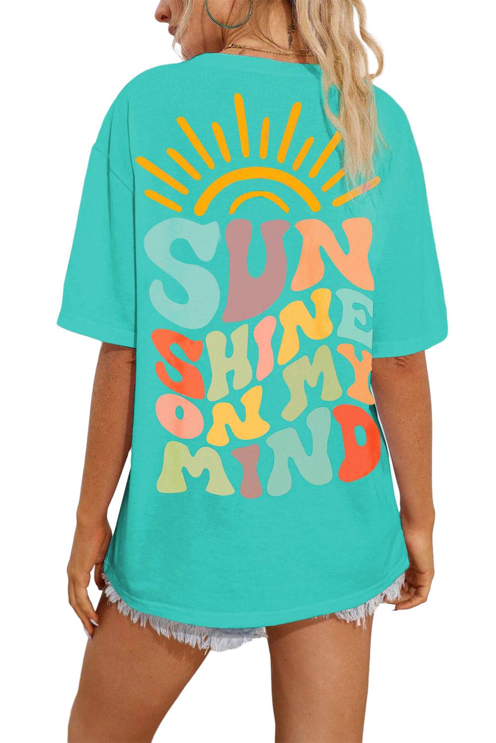 a woman wearing a turquoise shirt with the words sun shine on it