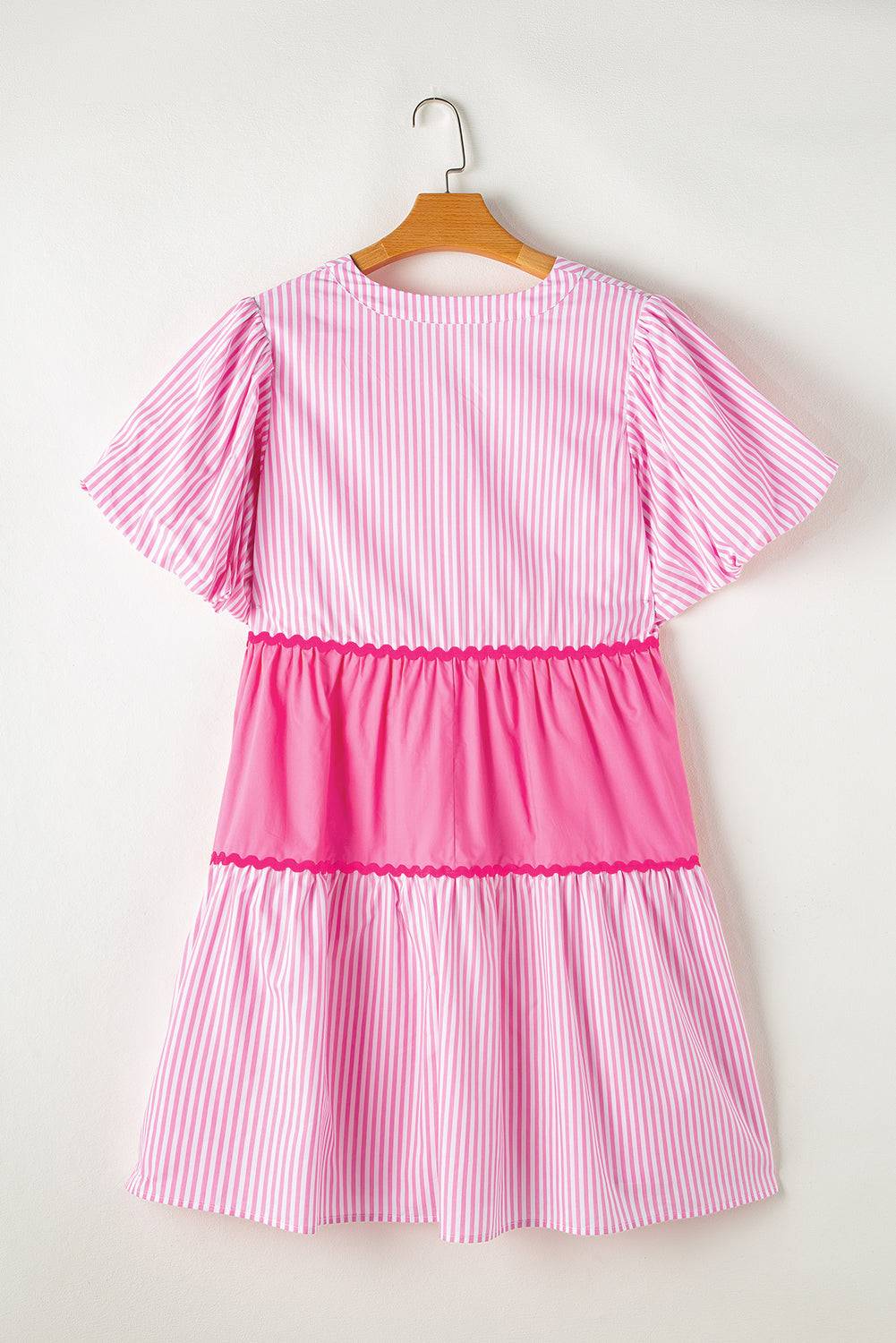 a pink and white striped dress hanging on a hanger