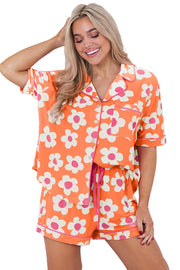 a woman wearing an orange and pink flower print pajama set