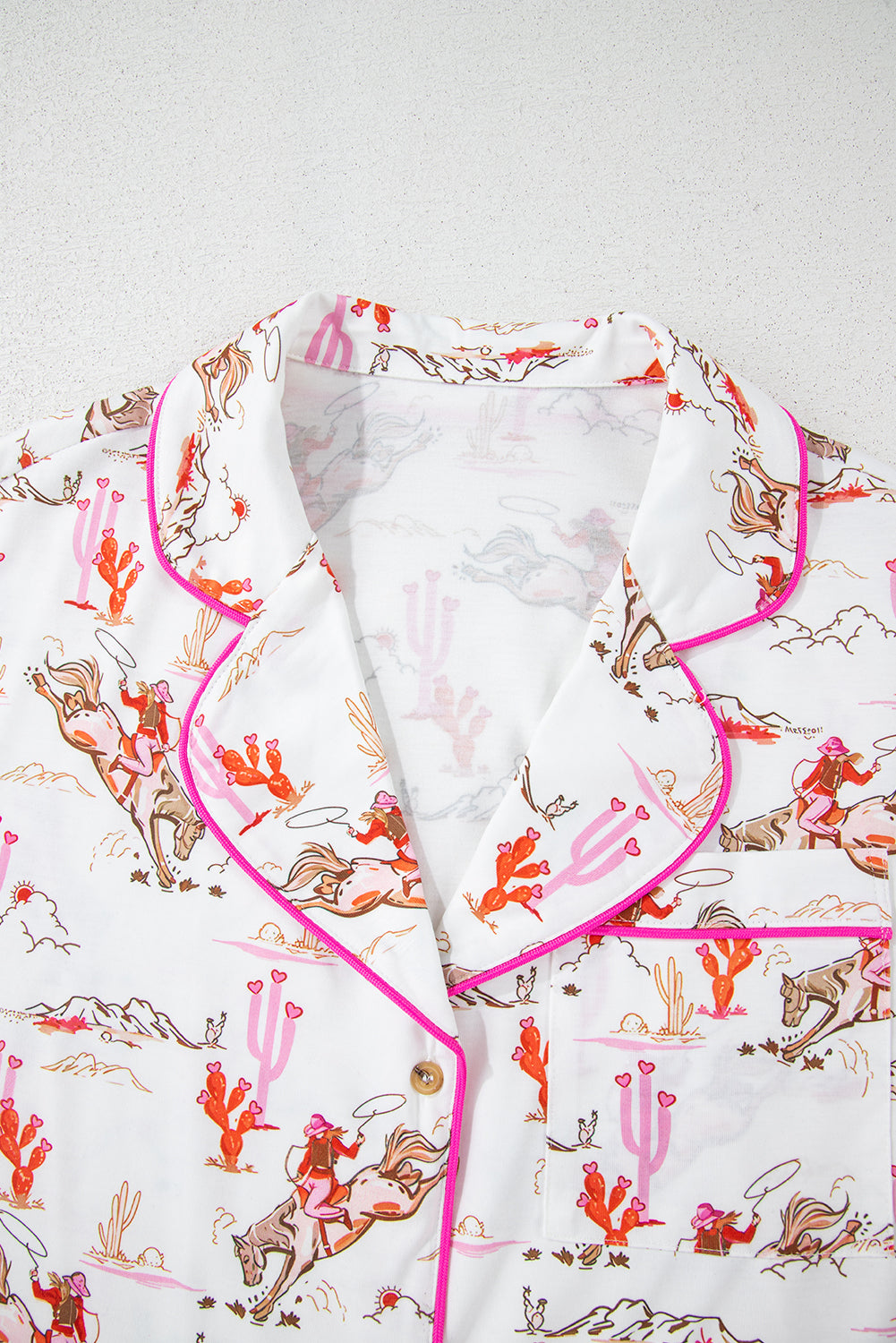 Chest pocket detail on White Cowgirl Country Print Pajamas Set with cowgirl and cactus illustrations. Shop White Cowgirl Country Print Pajamas Set at Faith & Co. Boutique.