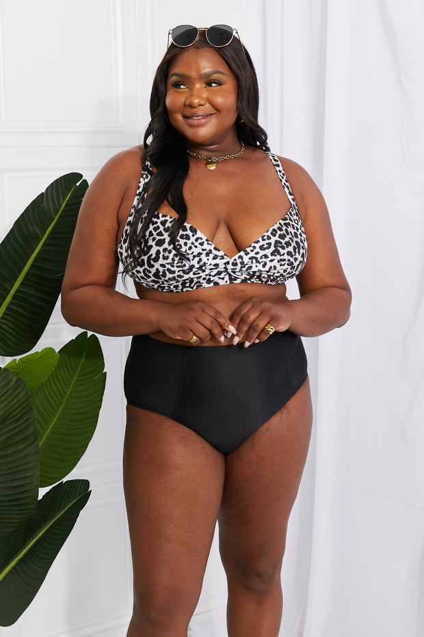 a woman in a leopard print top and black shorts