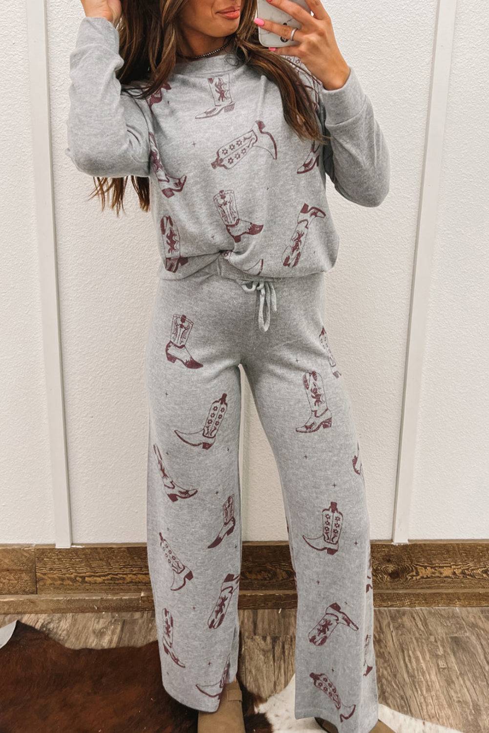 a woman wearing a grey sweatshirt and matching pants