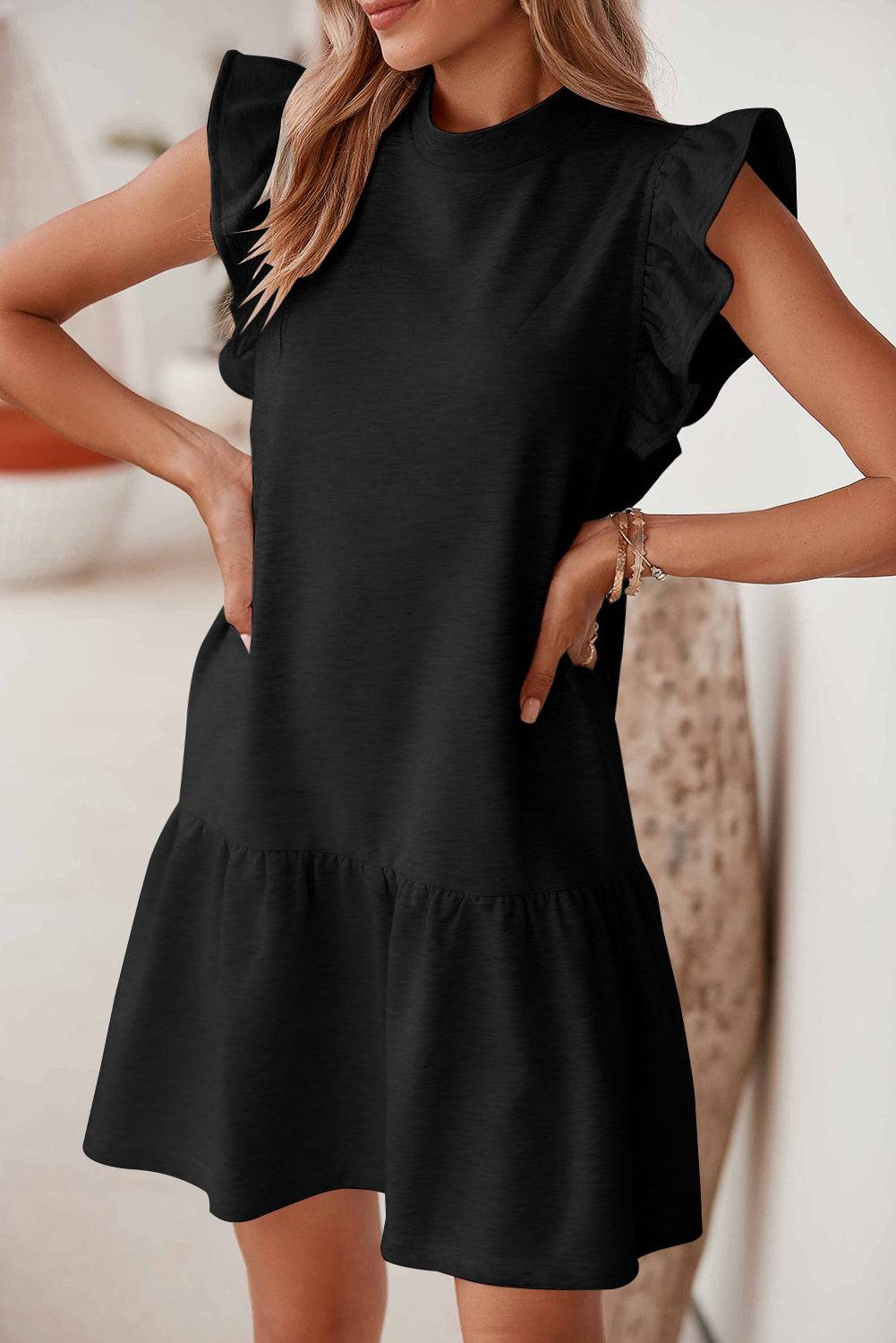 a woman wearing a black dress with ruffles