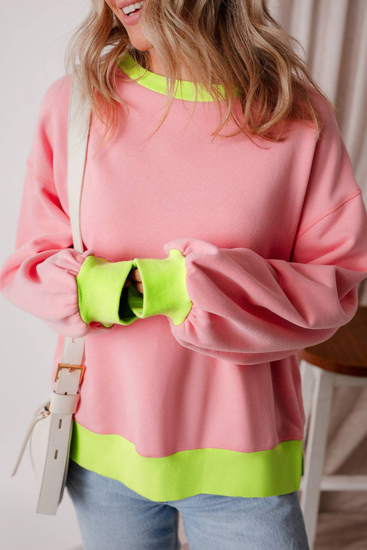 a woman wearing a pink and green sweater