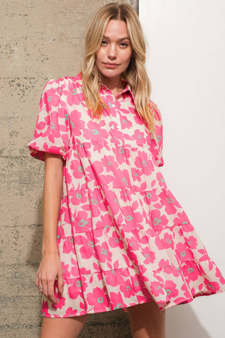 a woman in a pink dress standing next to a wall