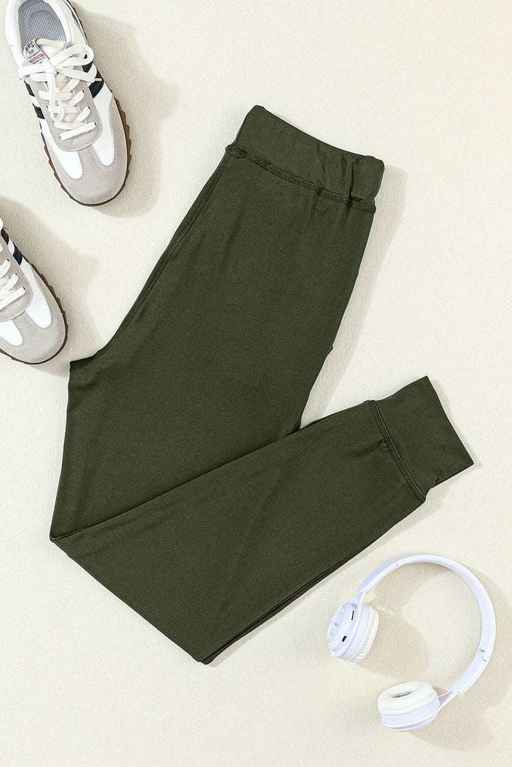 a pair of green pants, headphones and a pair of white shoes