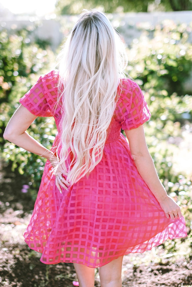 a woman with long blonde hair wearing a pink dress