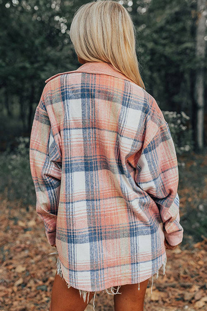 a woman standing in a forest wearing a plaid jacket