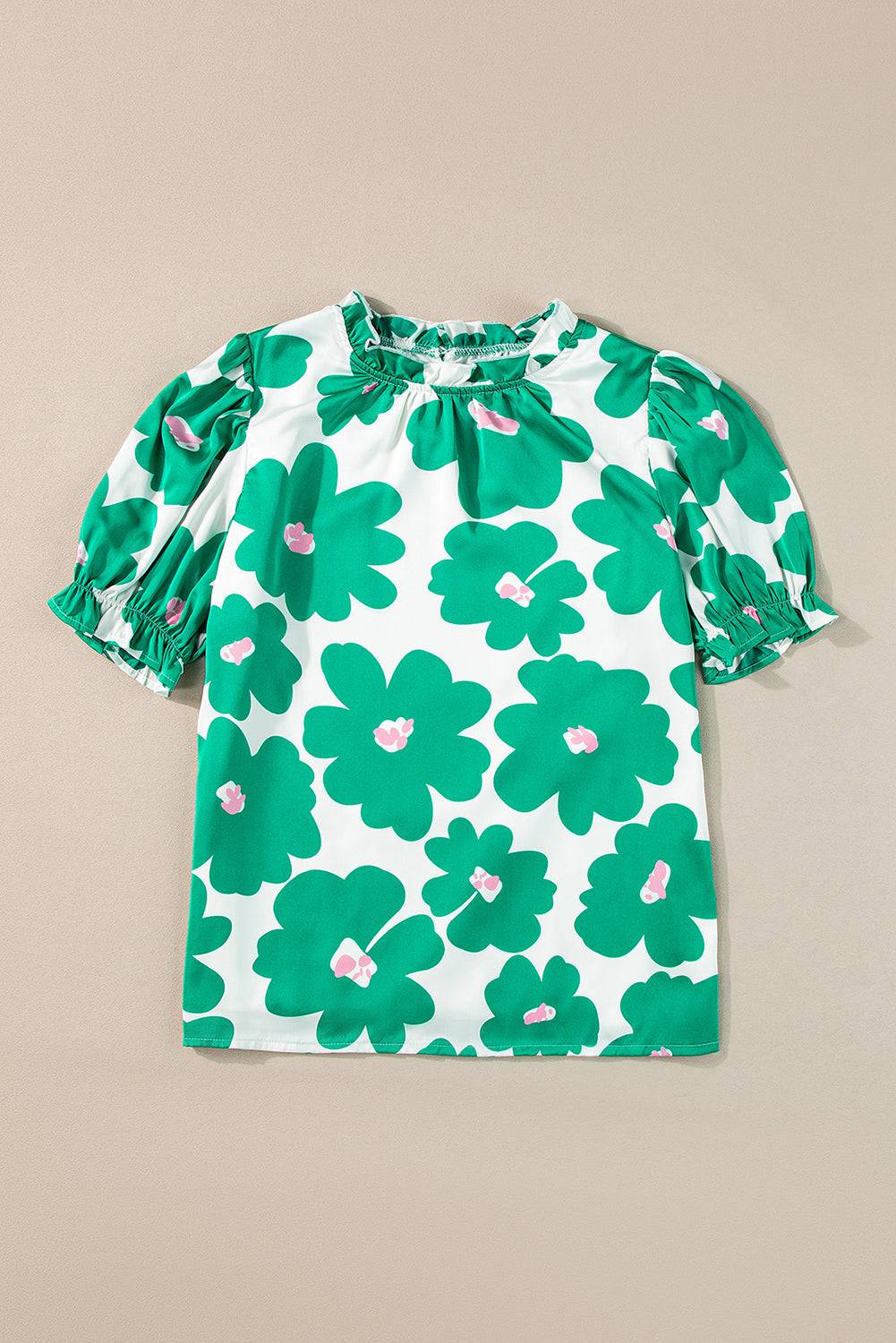 a green and white top with flowers on it