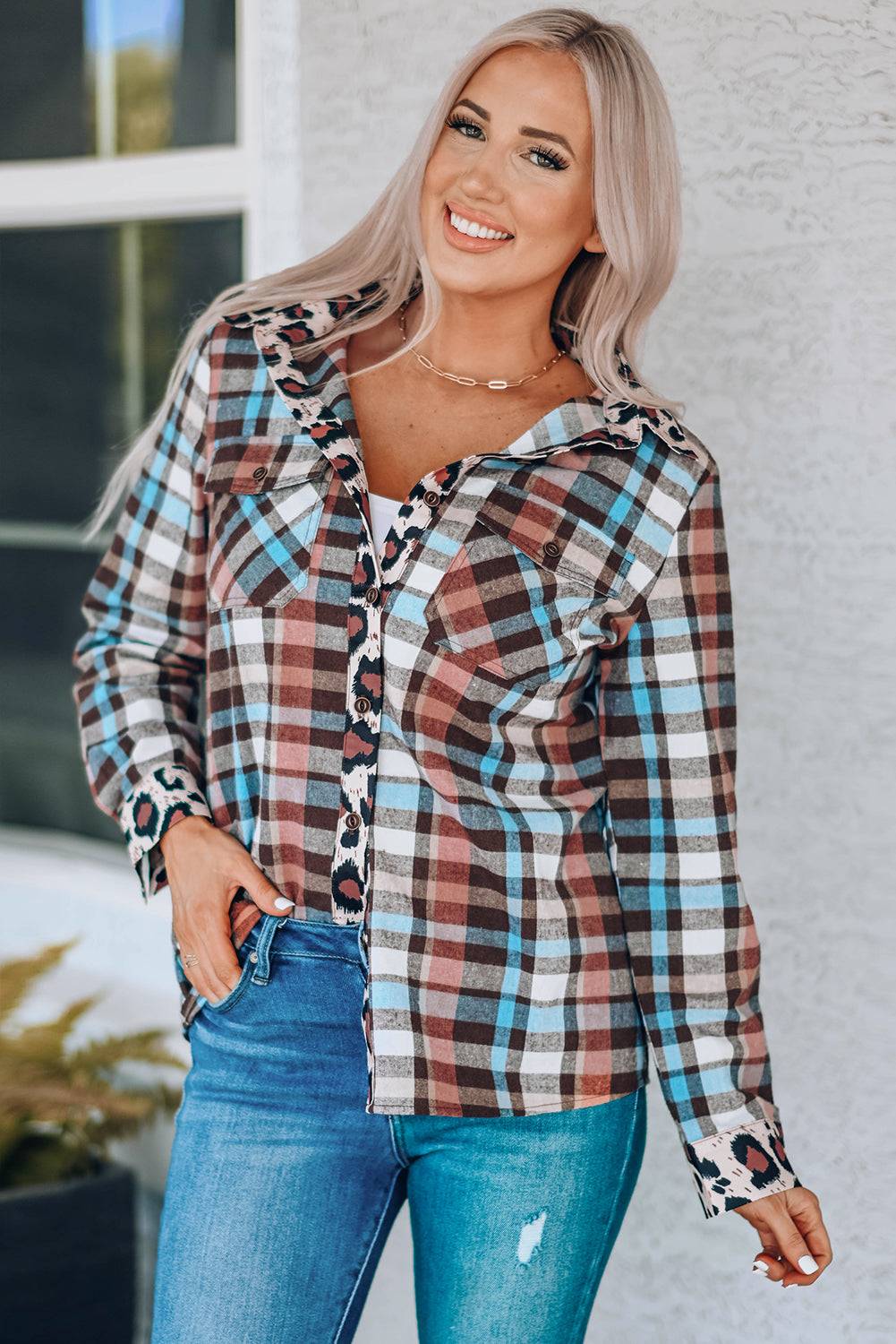 a woman wearing a plaid shirt and ripped jeans