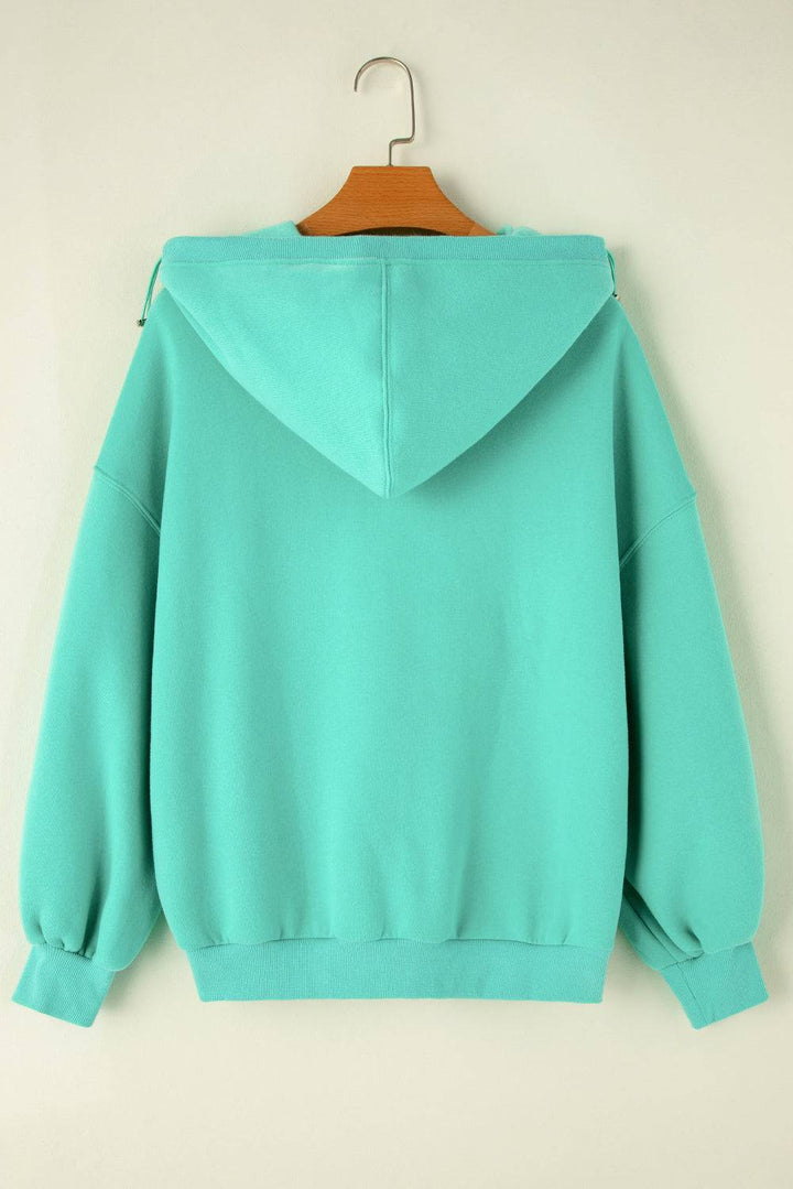 a green sweatshirt with a wooden hanger on it