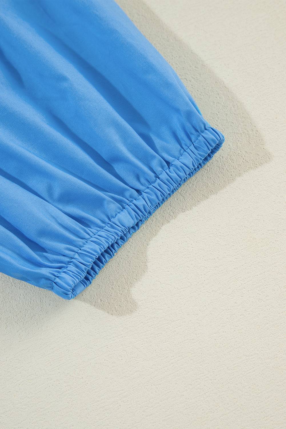 a close up of a blue skirt on a white surface