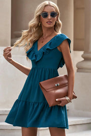 a woman in a blue dress holding a brown purse