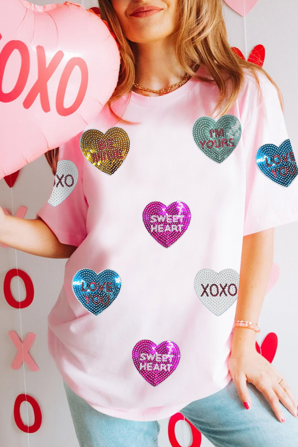 Pink Sequin Valentines Lettering Heart Patched Crewneck T Shirt styled with jeans, featuring colorful sequin hearts and romantic phrases. Shop at Faith & Co. Boutique.