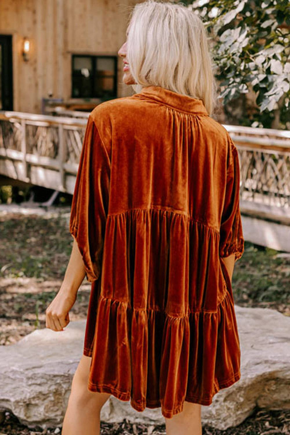 a woman in a brown dress walking towards a house