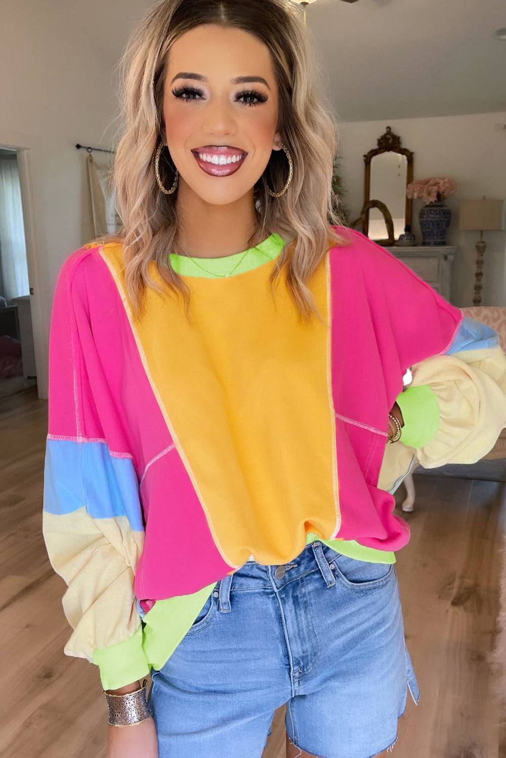 a woman standing in a room wearing a colorful top