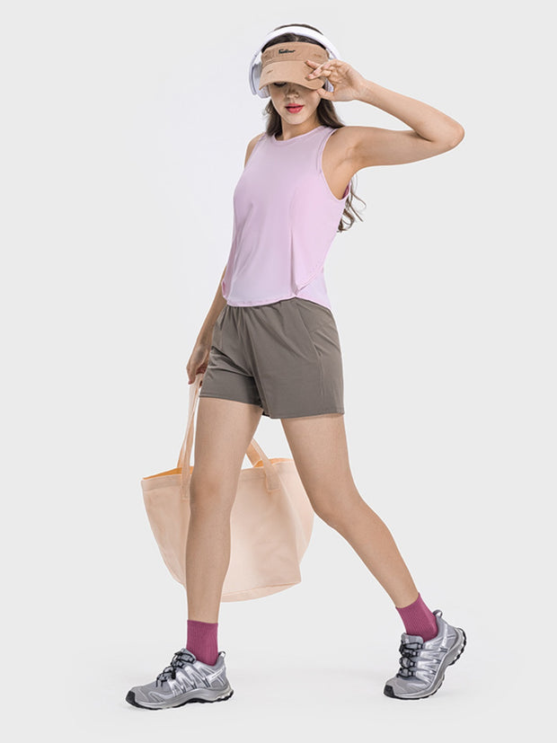 a woman in shorts and a pink shirt carrying a bag