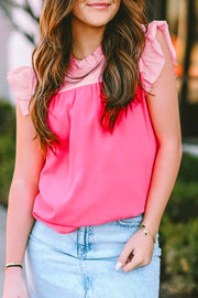a woman wearing a pink top and a denim skirt
