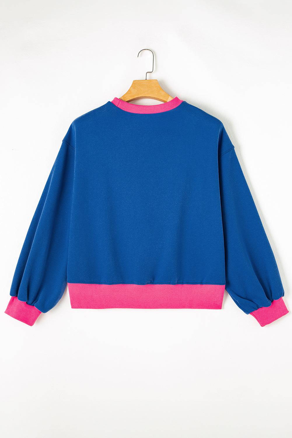 a blue and pink sweatshirt hanging on a hanger