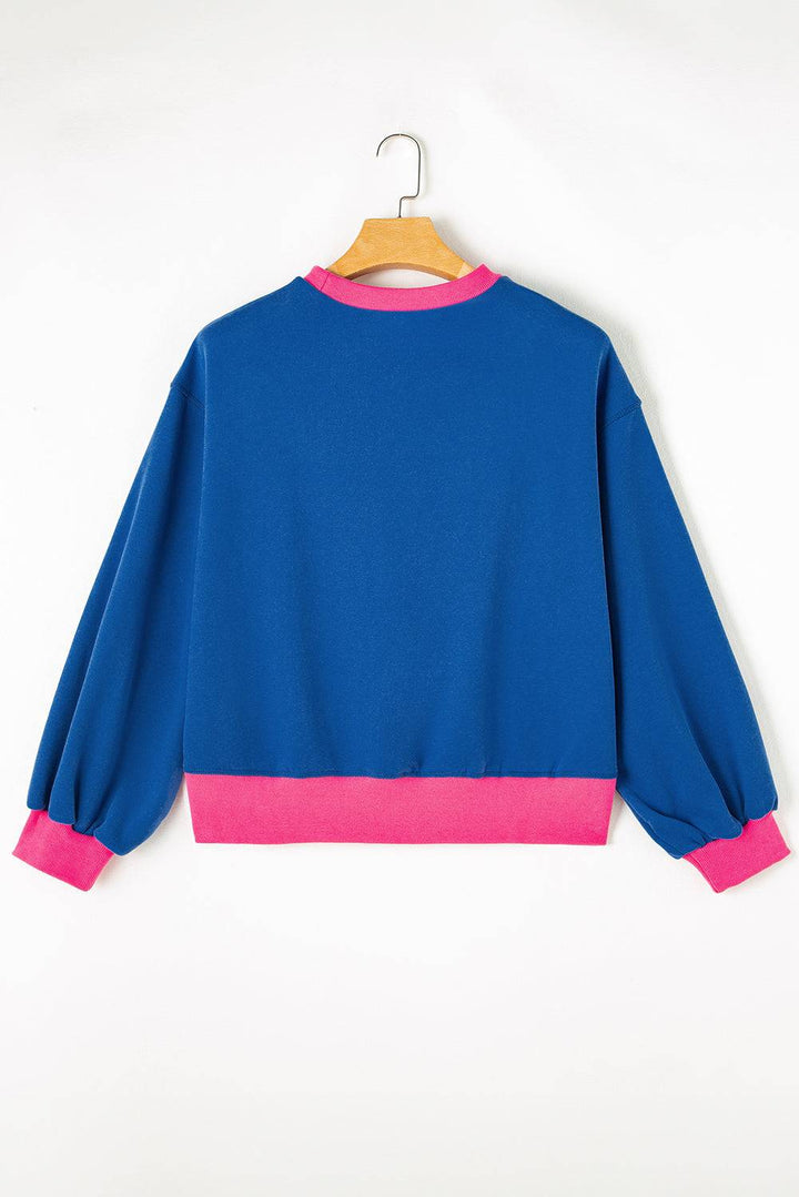 a blue and pink sweatshirt hanging on a hanger