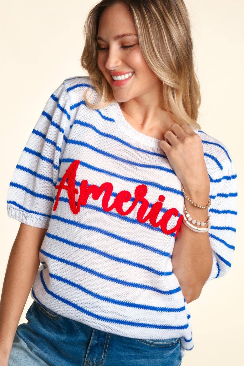 a woman wearing a sweater with the word america on it