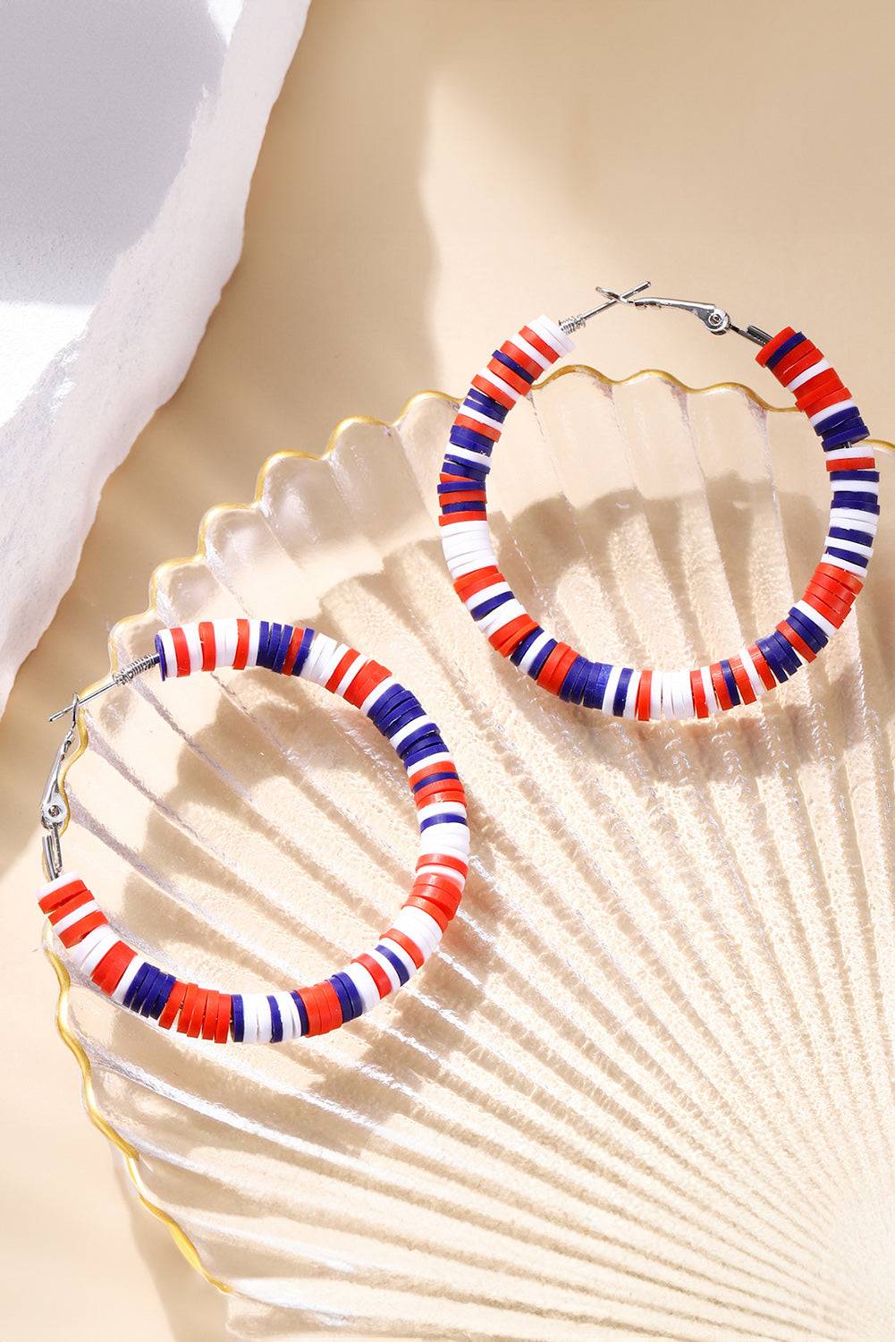 a pair of red, white, and blue hoop earrings