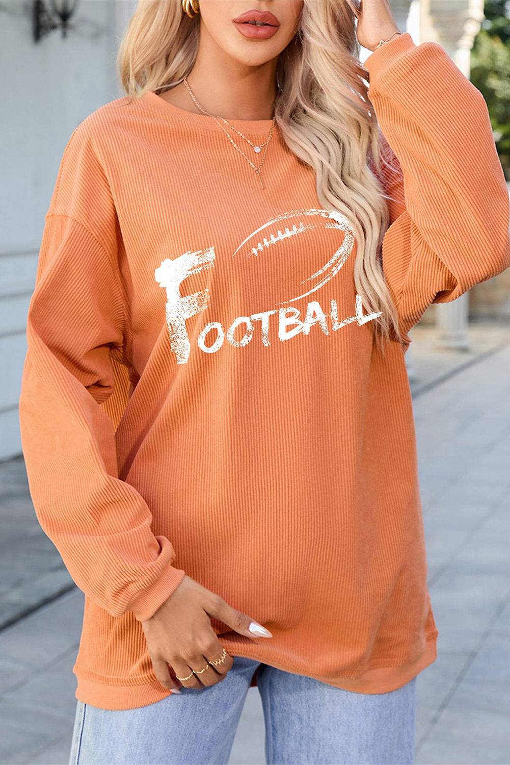 a woman wearing an orange football sweatshirt