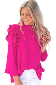 a woman wearing a pink top with ruffled sleeves