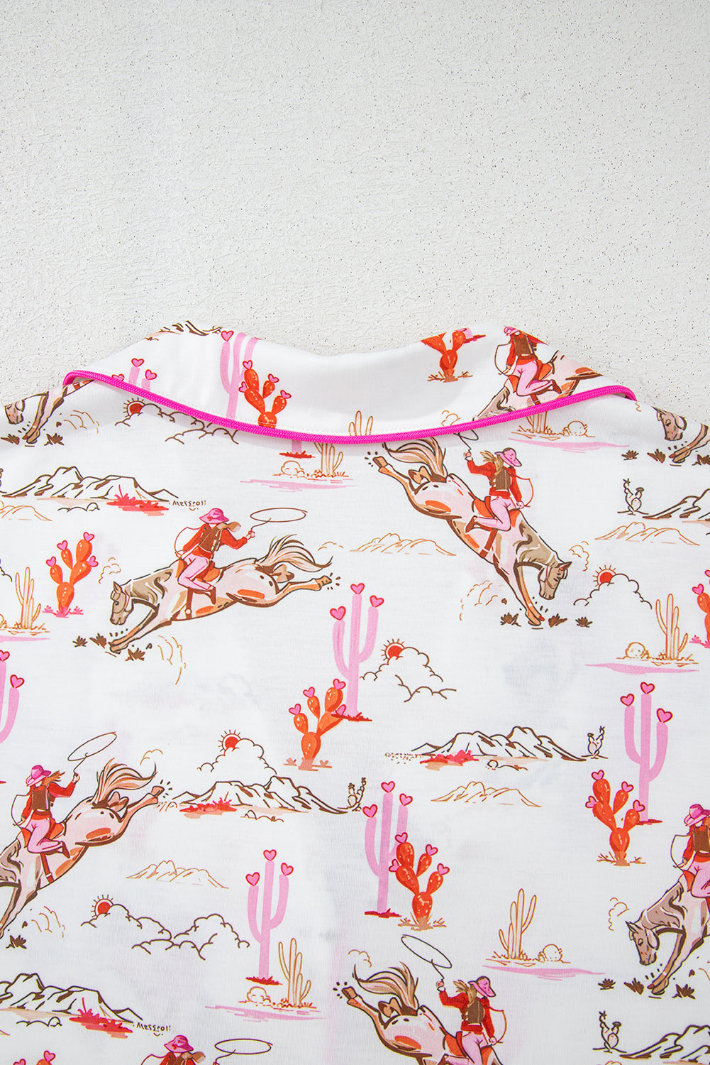 Sleeve hem detail of White Cowgirl Country Print Pajamas Set with pink trim and western motifs. Shop White Cowgirl Country Print Pajamas Set at Faith & Co. Boutique.