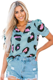 a woman wearing a blue top with pink and black spots