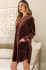 a woman standing on a bed wearing a brown robe