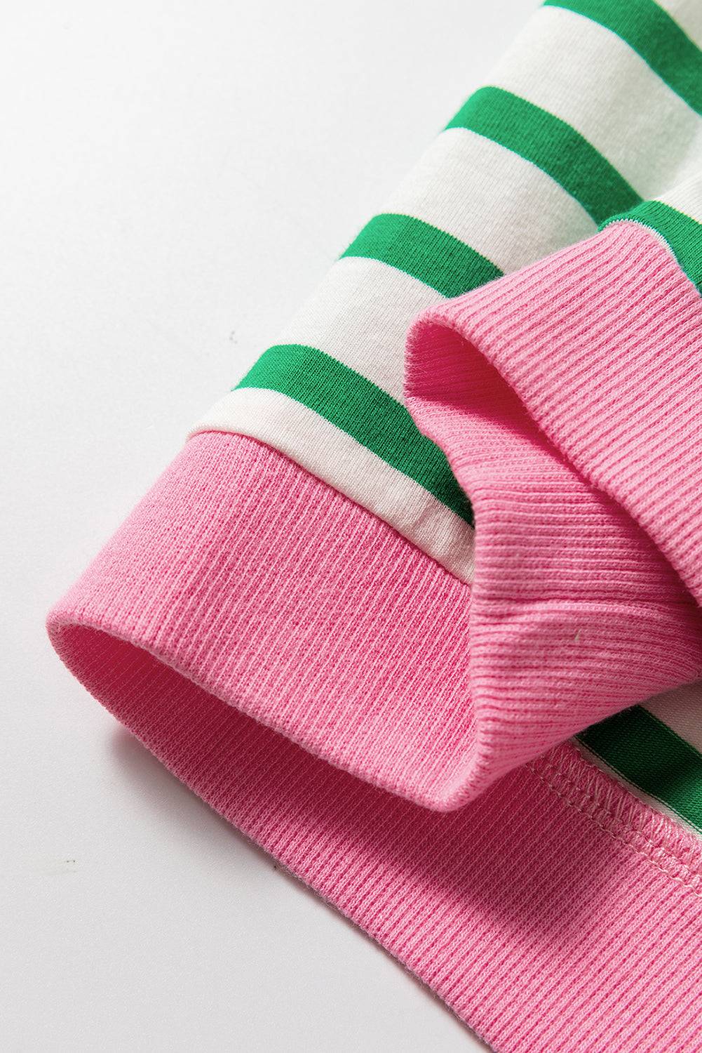 a close up of a pink and green striped sweater