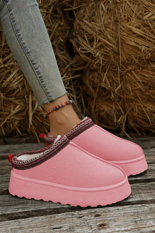 a woman's feet wearing pink shoes and jeans
