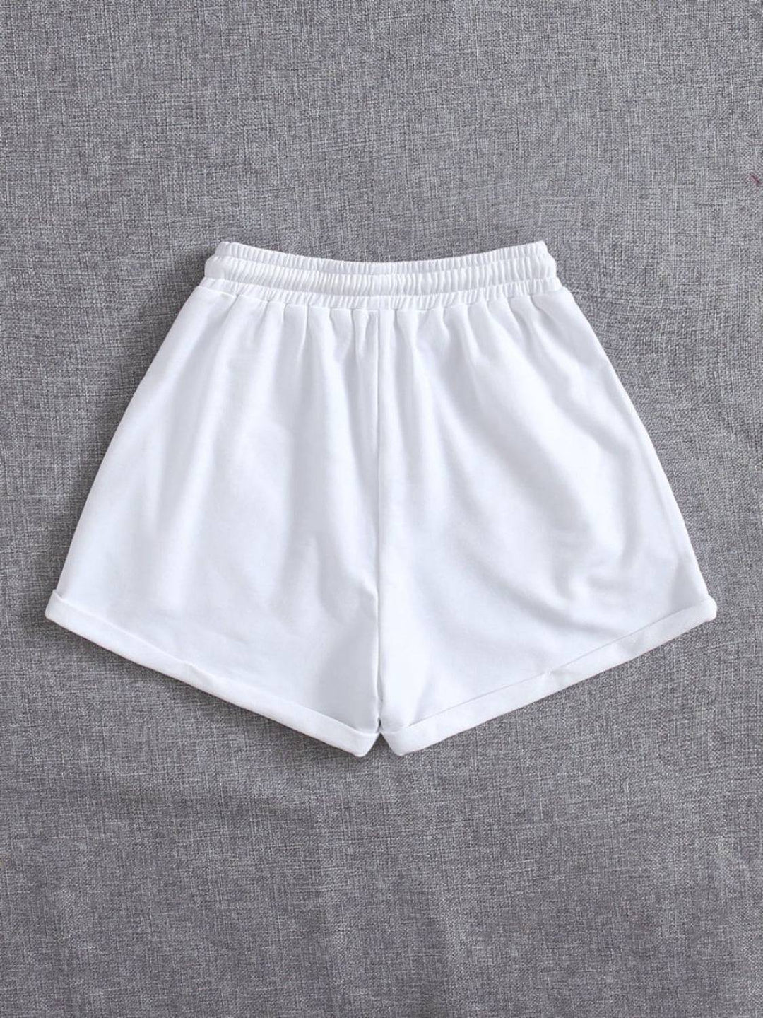 a pair of white shorts sitting on top of a bed