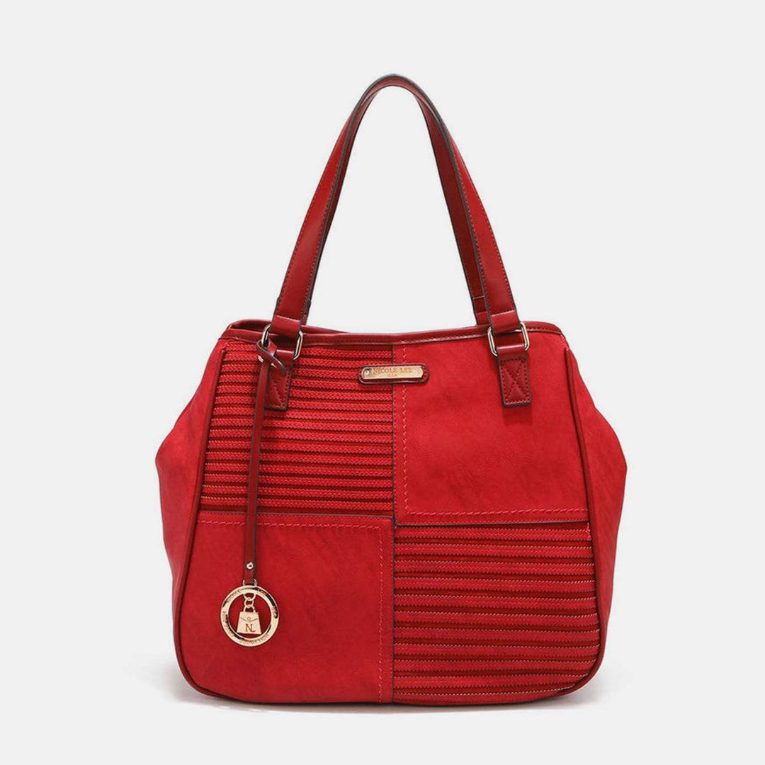 a red handbag with a small bell on the front