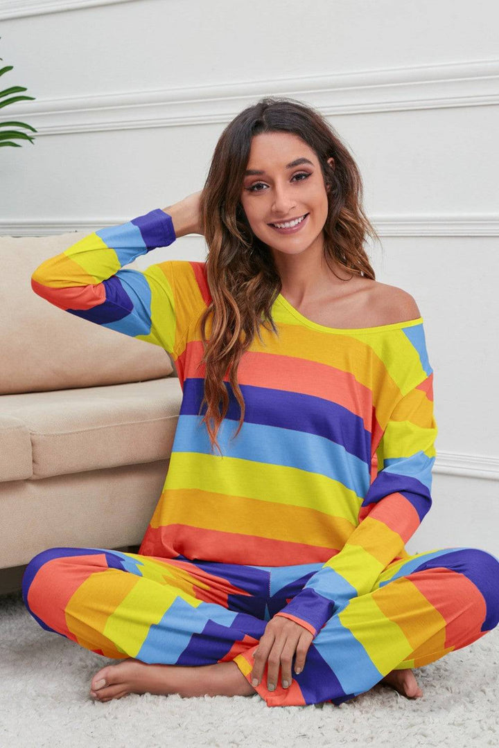 a woman sitting on the floor wearing a rainbow striped outfit