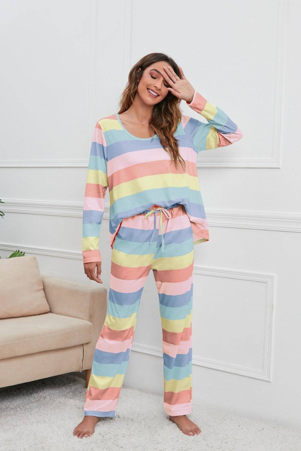 a woman wearing a rainbow striped pajama set