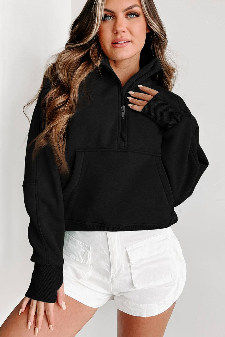 a woman wearing a black sweatshirt and white shorts