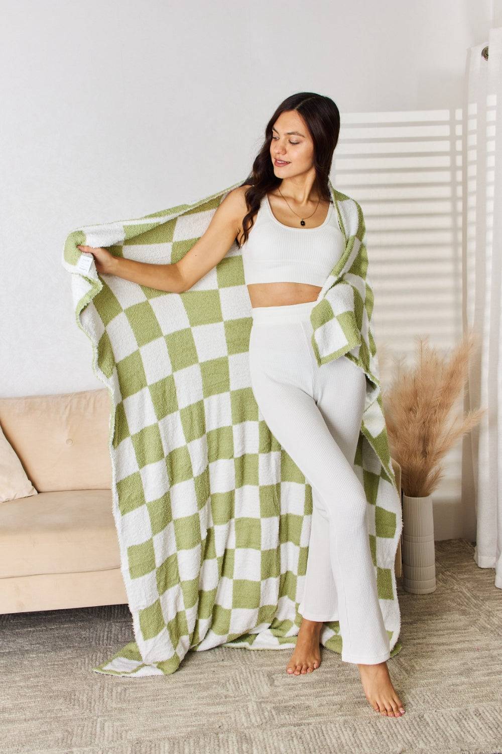 a woman holding a green and white checkered blanket