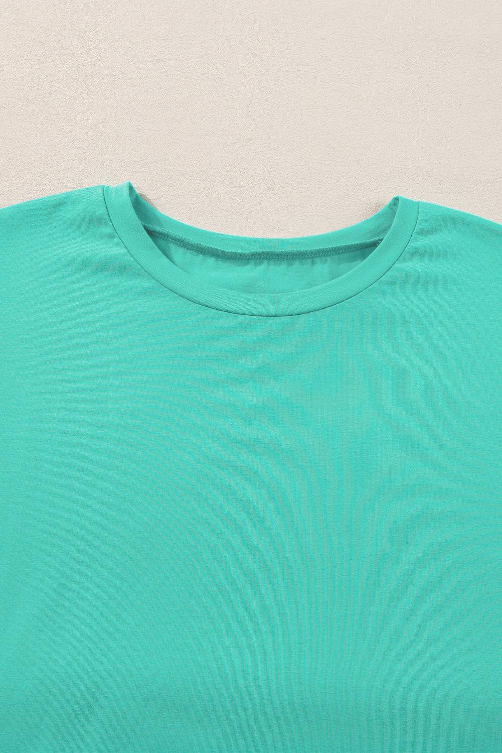 a close up of a green shirt on a white surface