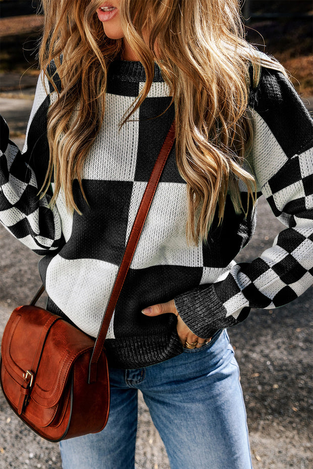 a woman in a black and white sweater holding a brown purse