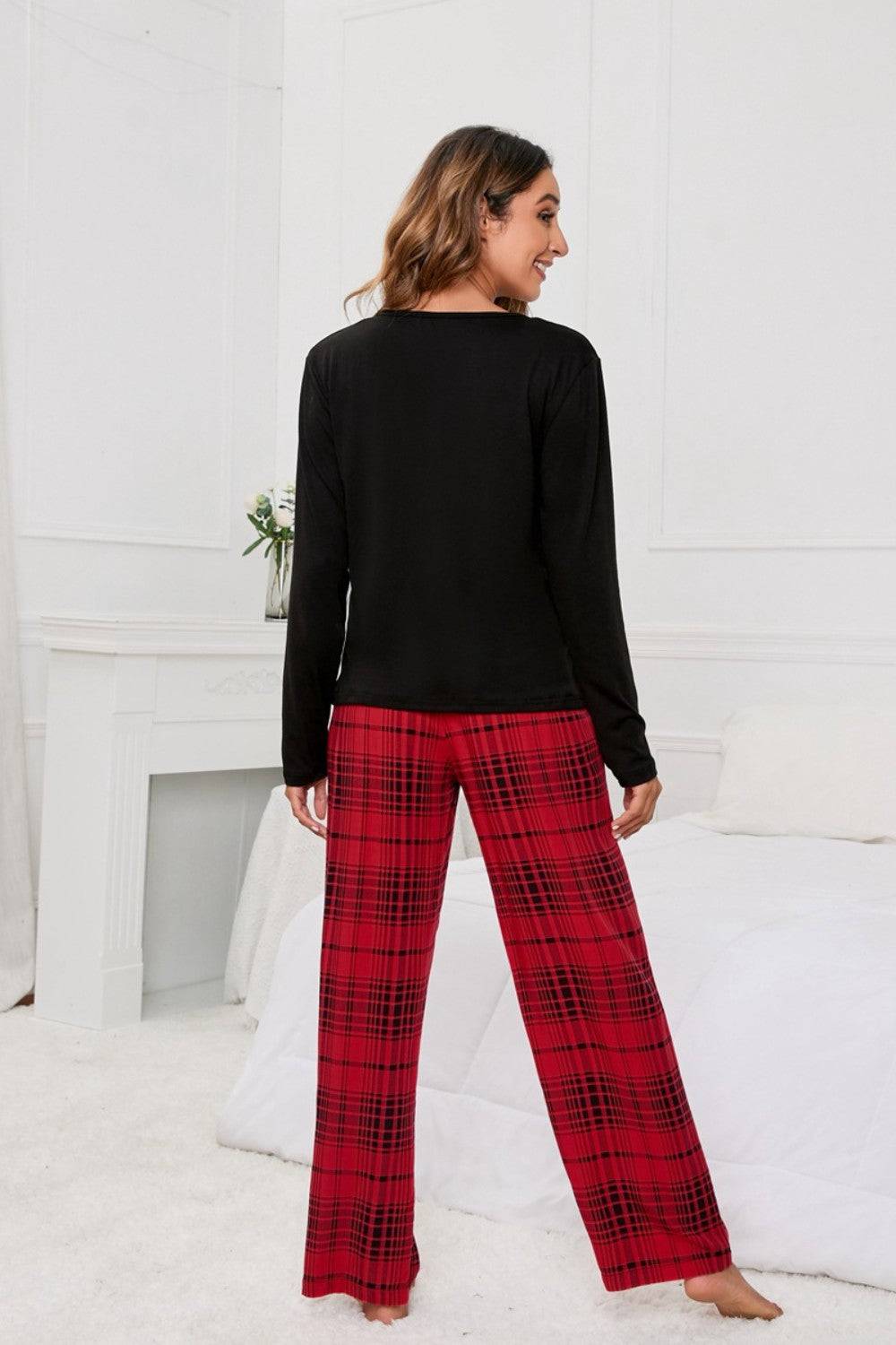 a woman in a black top and red plaid pants