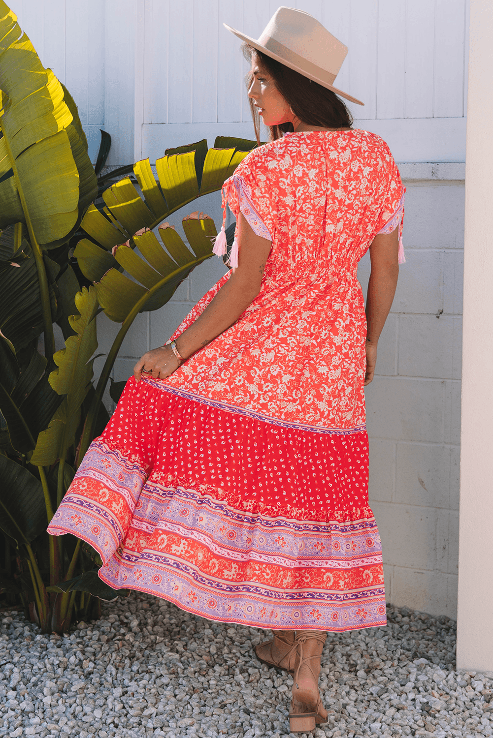 back view of model in Red Floral Print Tasseled Tied Sleeve Empire Waist Maxi Dress, highlighting tiered skirt and relaxed fit