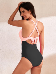 a woman in a black and pink one piece swimsuit