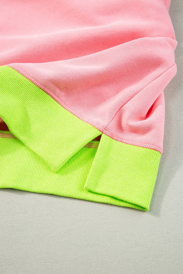 a pink and green shirt laying on top of a table