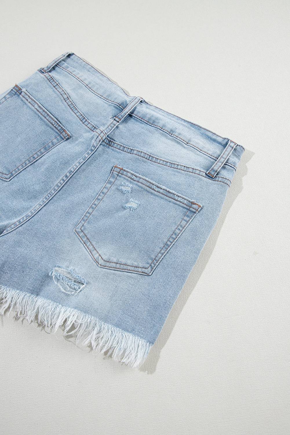 a pair of light blue jean shorts with fringes