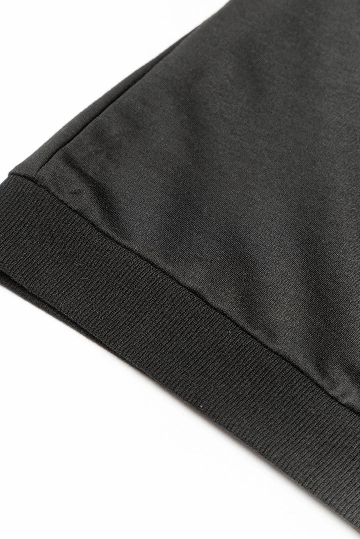 a close up of a black shirt on a white surface