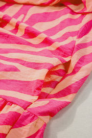 a pink and orange striped dress laying on a white surface